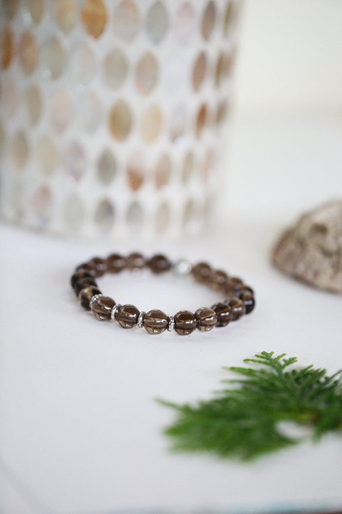 Stylish gemstone bracelet displayed on a white surface with decorative elements.