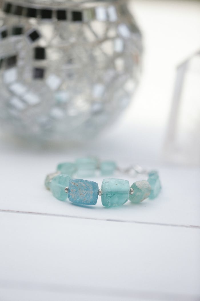 A stunning aqua crystal bracelet showcased on a minimalist white table, highlighting its elegant charm.